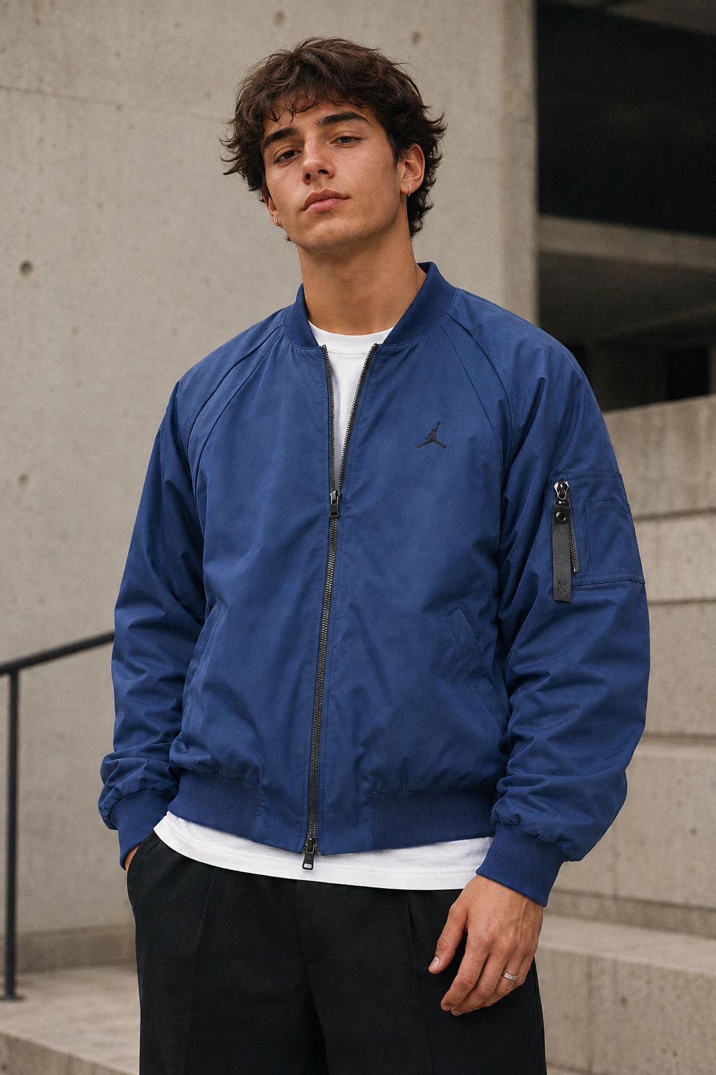 Front view of the blue Nike Air Jordan Jumpman MA-1 bomber jacket on a model